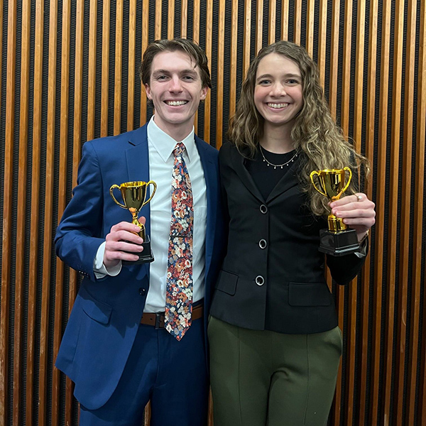 two students holding throphies