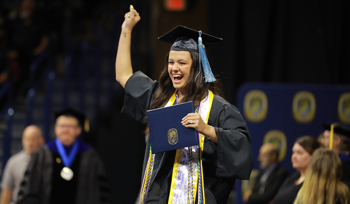 A female student at graduation wearing a cap and gown