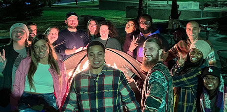 students gathered around firepit