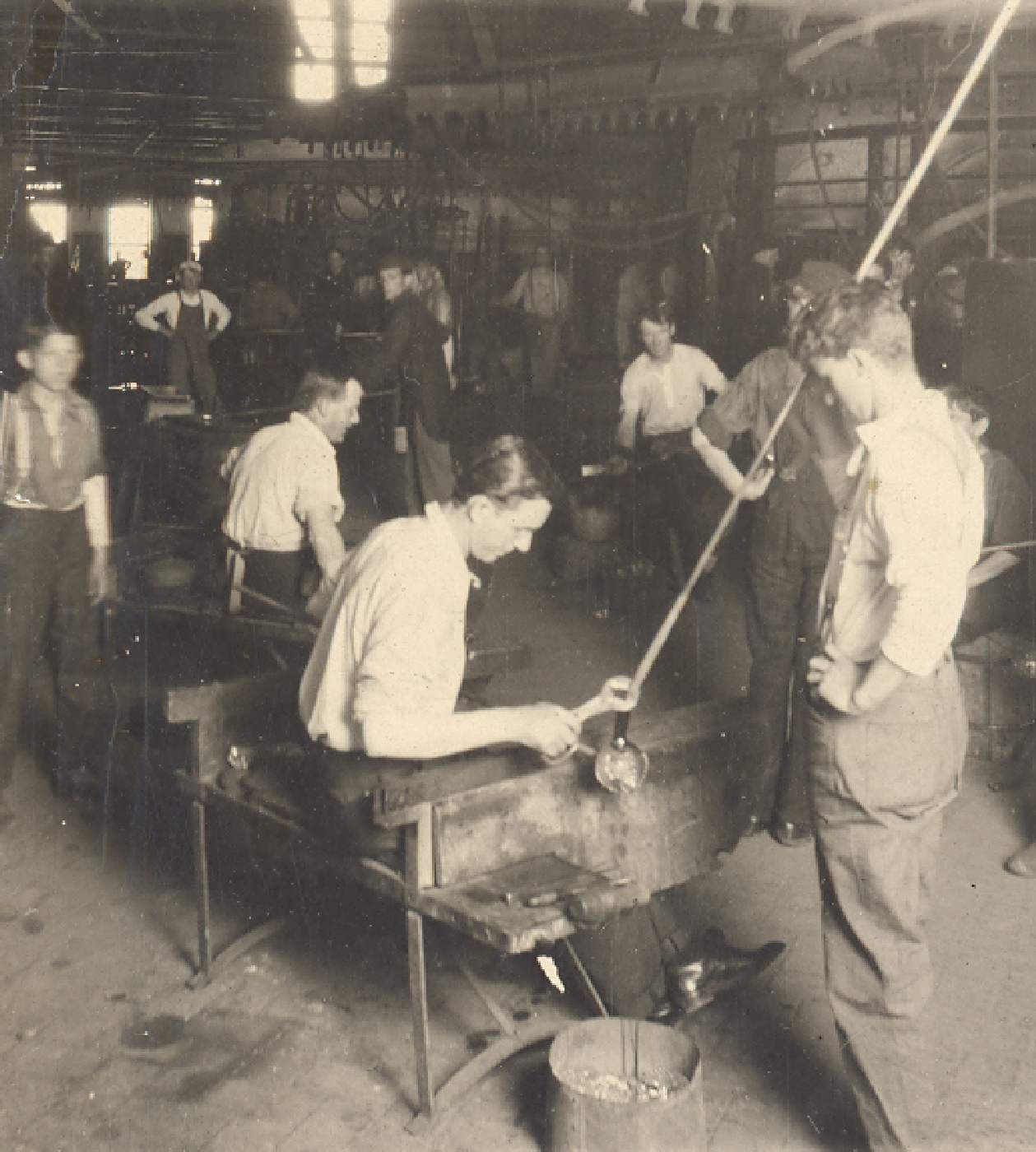 Glass workers making light bulb by hand