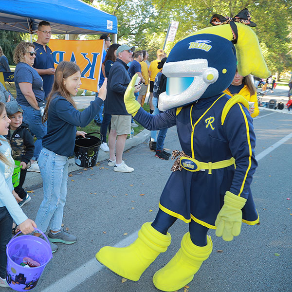 rocksy giving high fives to kids at homecoming parade