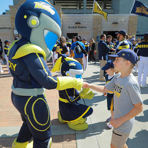 rocky giving a fist bump to a kid at a pre-football game event