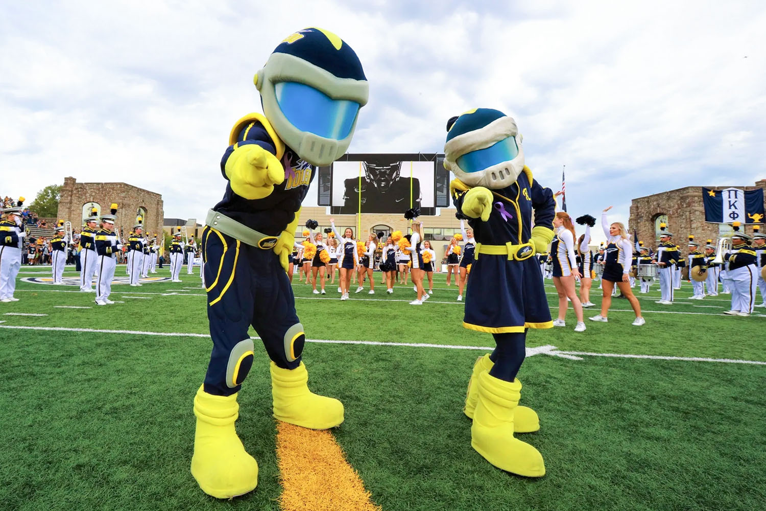 Rocky and Rocksy pre-football game on the field at Glass Bowl Stadium pointing at the camera