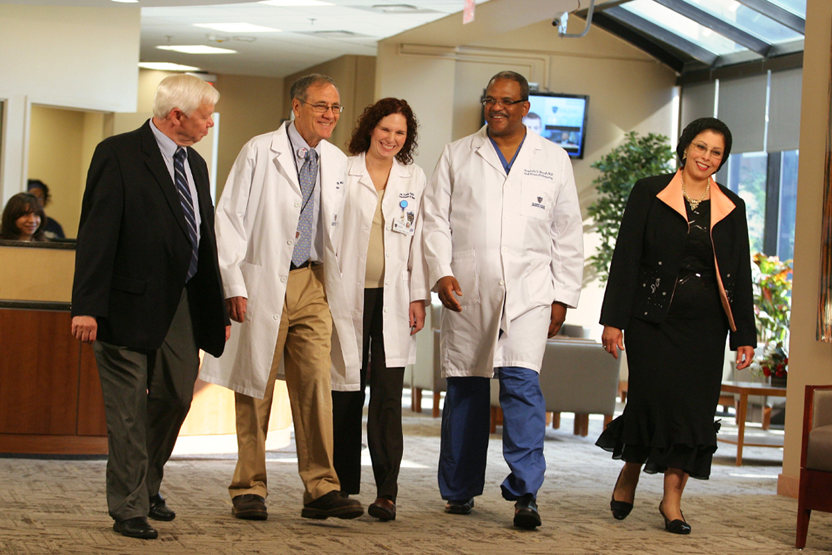 Dr. Baugh pictured with colleagues walking through UTMC's lobby in 2011