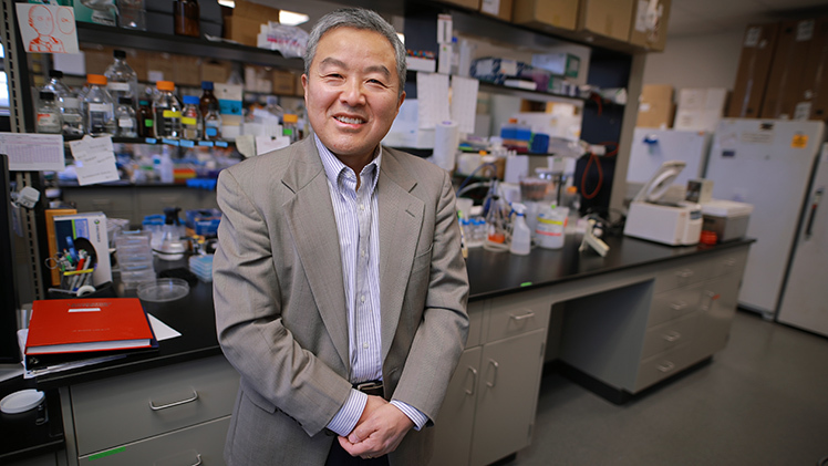 Dr. Zhang standing in his lab