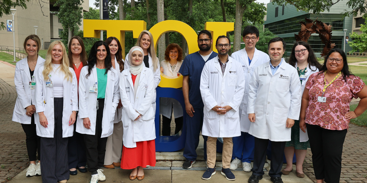 Group photo in front of TOL-EDO sign on campus