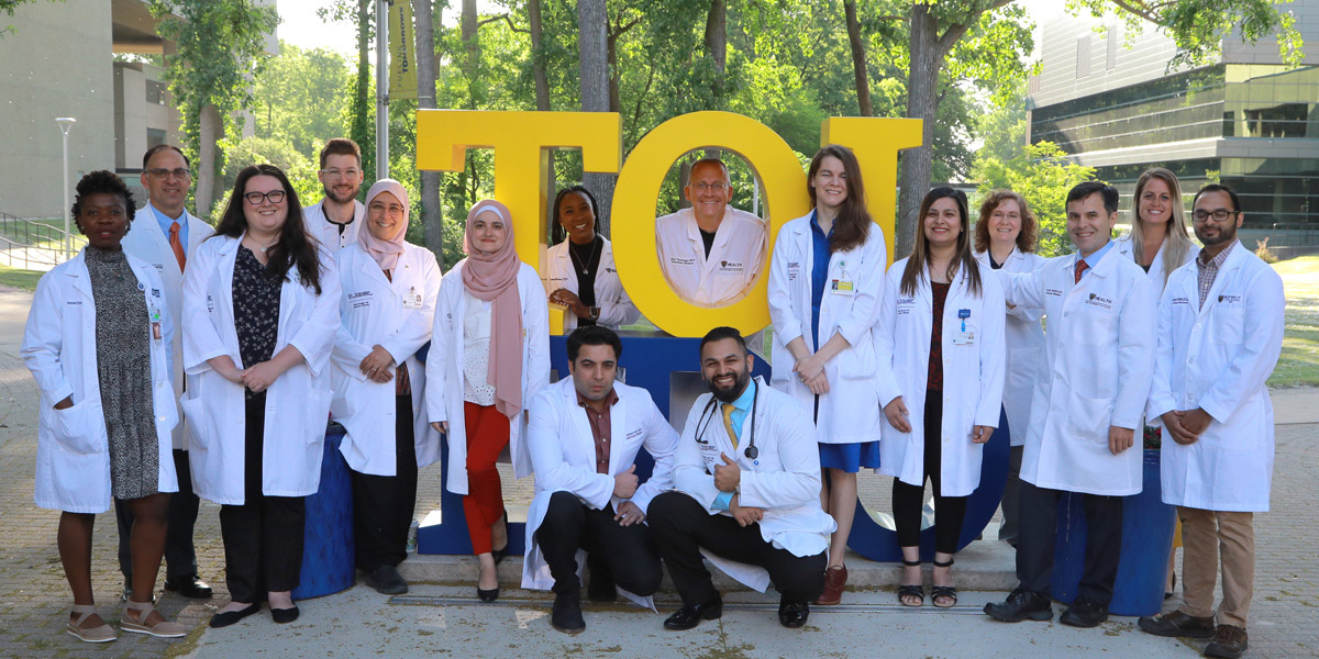 Group photo in front of TOL-EDO sign on campus