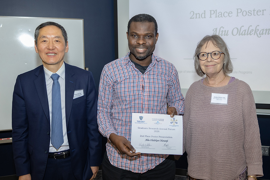 An award recipient stands with Dr. Williams and keynote speaker Dr. Huang.