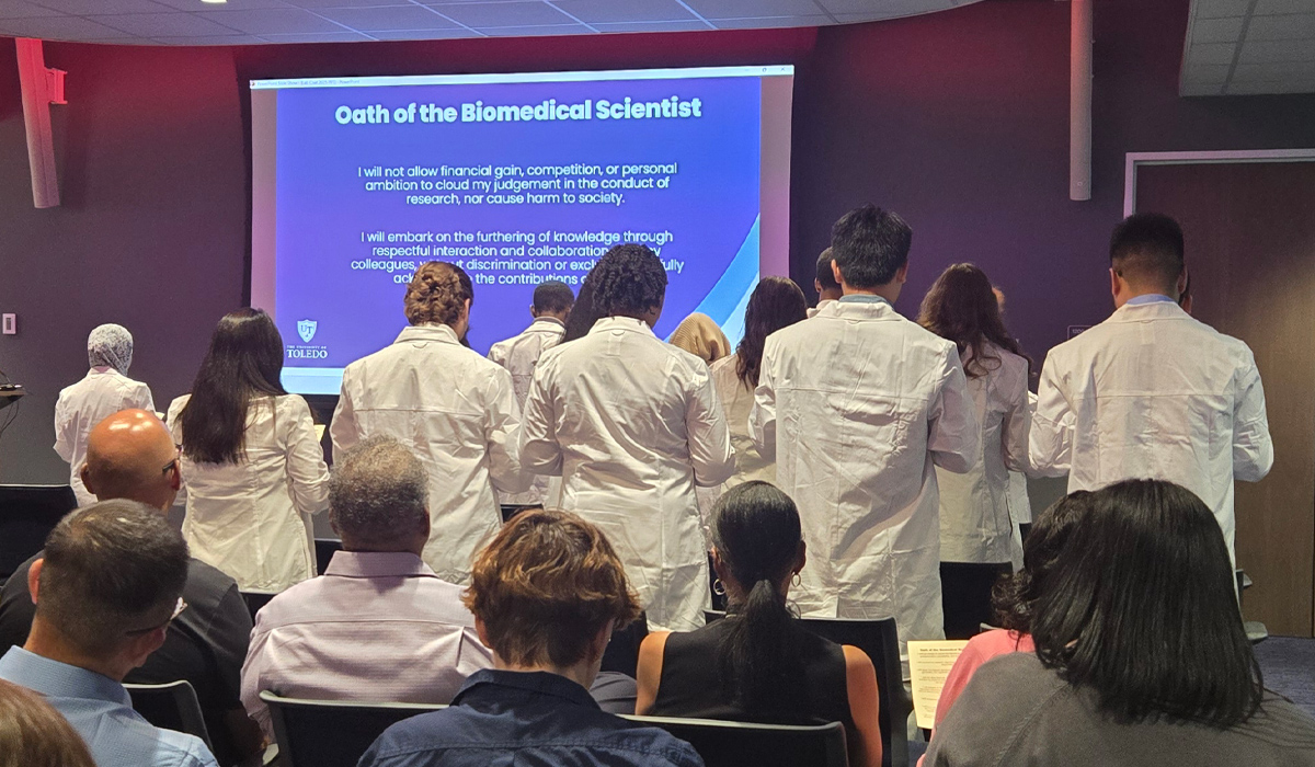 Student read the pledge during the 2025 Biomedical Lab Coat Ceremony, while wearing their new lab coats.