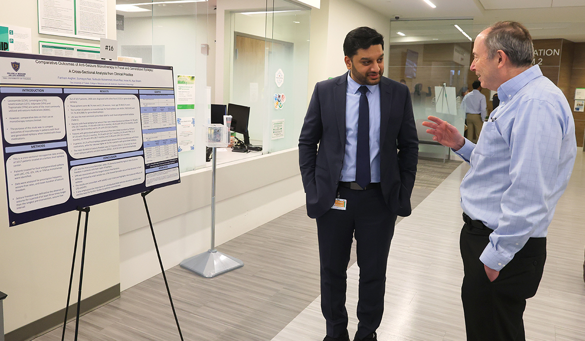 Neurology resident Dr. Fahham Asghar discusses his research poster, "Comparative Outcomes of Anti-Seizure Monotherapy in Focal and Generalized Epilepsy: A Cross-Sectional Analysis from Clinical Practice," with Dr. Boyd Moreau Koffman during a poster session.