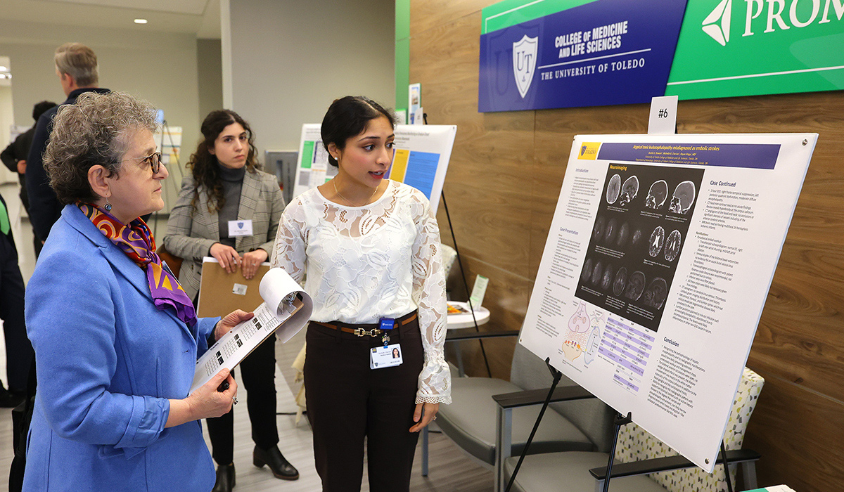 Third-year medical student Michelle R. Cherian presents her poster, titled “Atypical toxic leukocephalopathy misdiagnosed as embolic strokes,” to Dr. Laurie Gutmann.