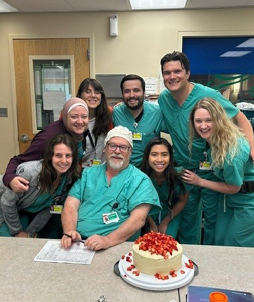 Dr. Harpert with residents and cake on the table