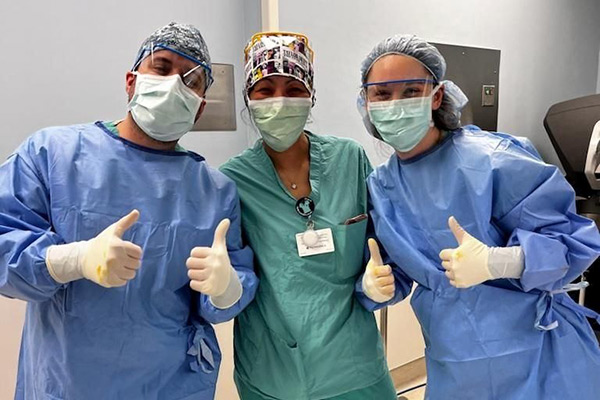 Jena and two others in scrubs in a clinical setting.