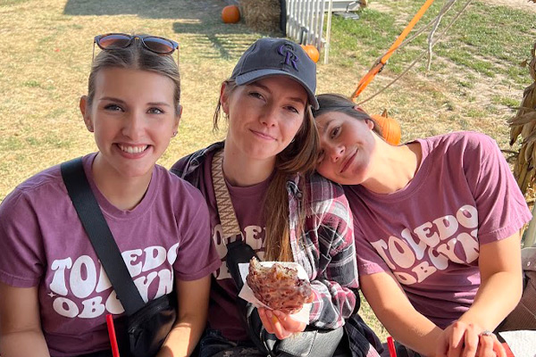 Laura, Kristi, and Alex with donuts at an outing.