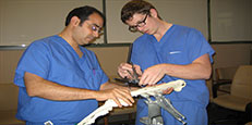 residents working on leg bone in lab