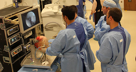 residents looking at monitor while performing simulated operation