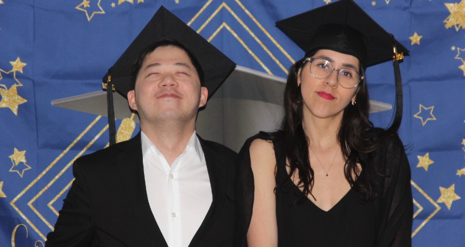 Two residents with graduation apparel