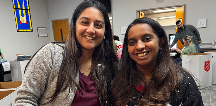 Two members of the department at a holiday donation drive event inside a church.