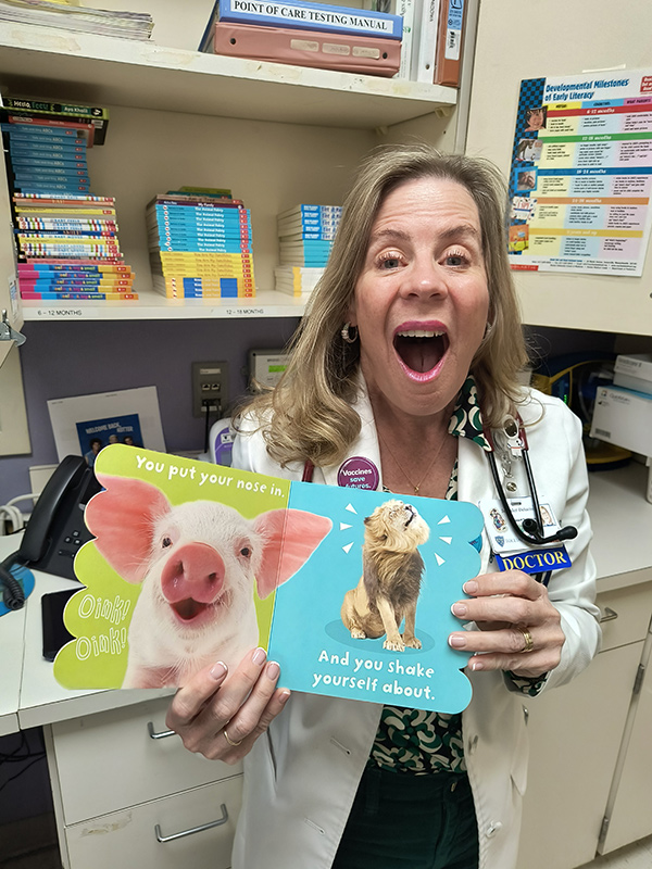 Dr. DeLucia excitedly showcases a book as part of the program.