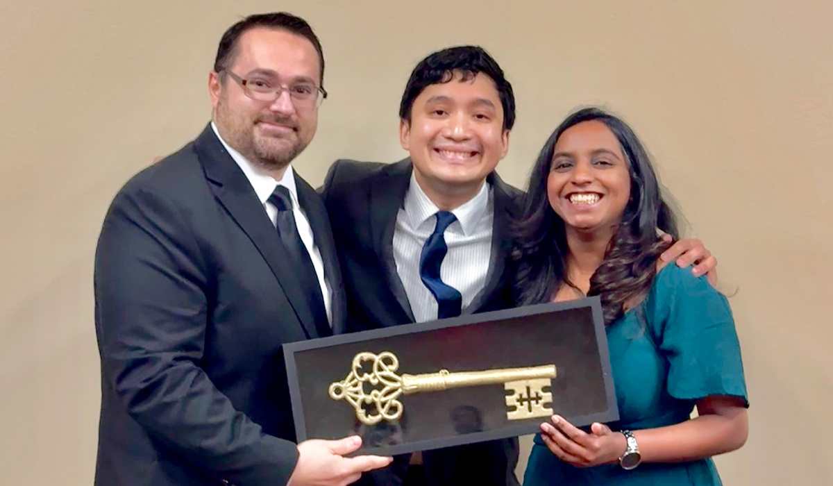 Three pediatric chief residents—Drs. Ahmed Klobocista, David Garcia, and Ronitha Madras Kumar—stand together smiling and holding a framed ceremonial key.