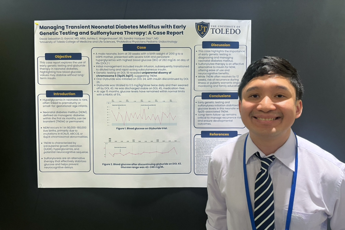 Pediatric resident stands smiling beside a University of Toledo research poster on managing transient neonatal diabetes mellitus, featuring case details, graphs, and clinical conclusions.