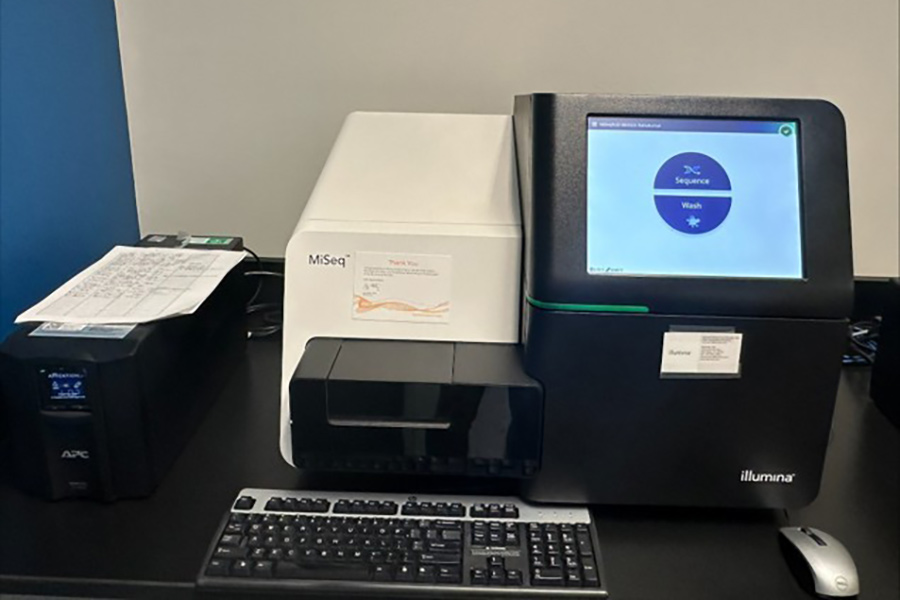 Illumina MiSeq benchtop DNA sequencer with monitor and keyboard, used for high-throughput microbial sequencing.