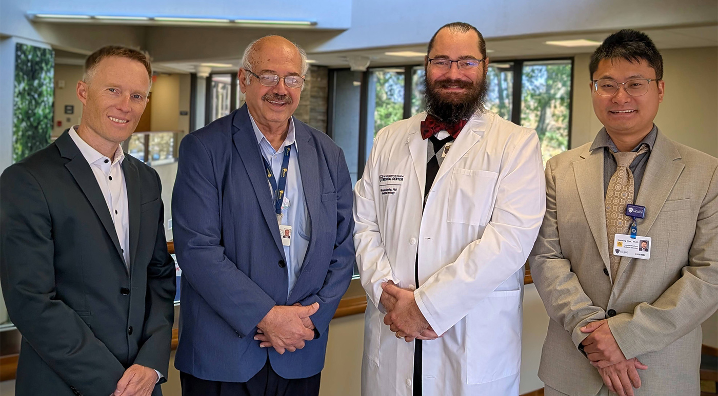 Four faculty members pose for a group photo.