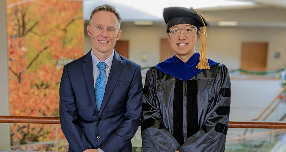 Dr. Pearson pictured with a graduate wearing a cap and gown