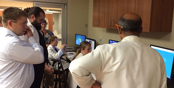 students and faculty looking at computer monitors