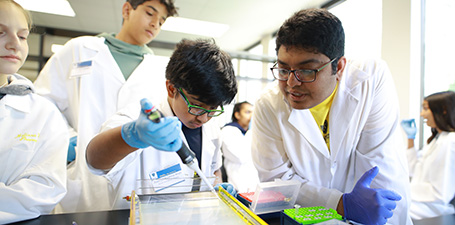 A young student works in a lab during a camp.