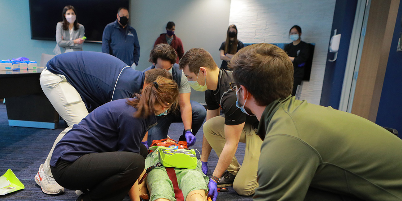 Students participate in an EMS-EMT athletic trainer and cross training evening, with a simluated patient on a gurney. 