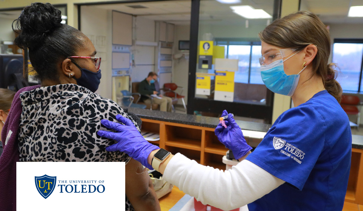 A student gives a COVID-19 vaccine to a healthcare employee. 