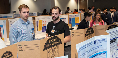 Two attendees look at a poster during the symposium.