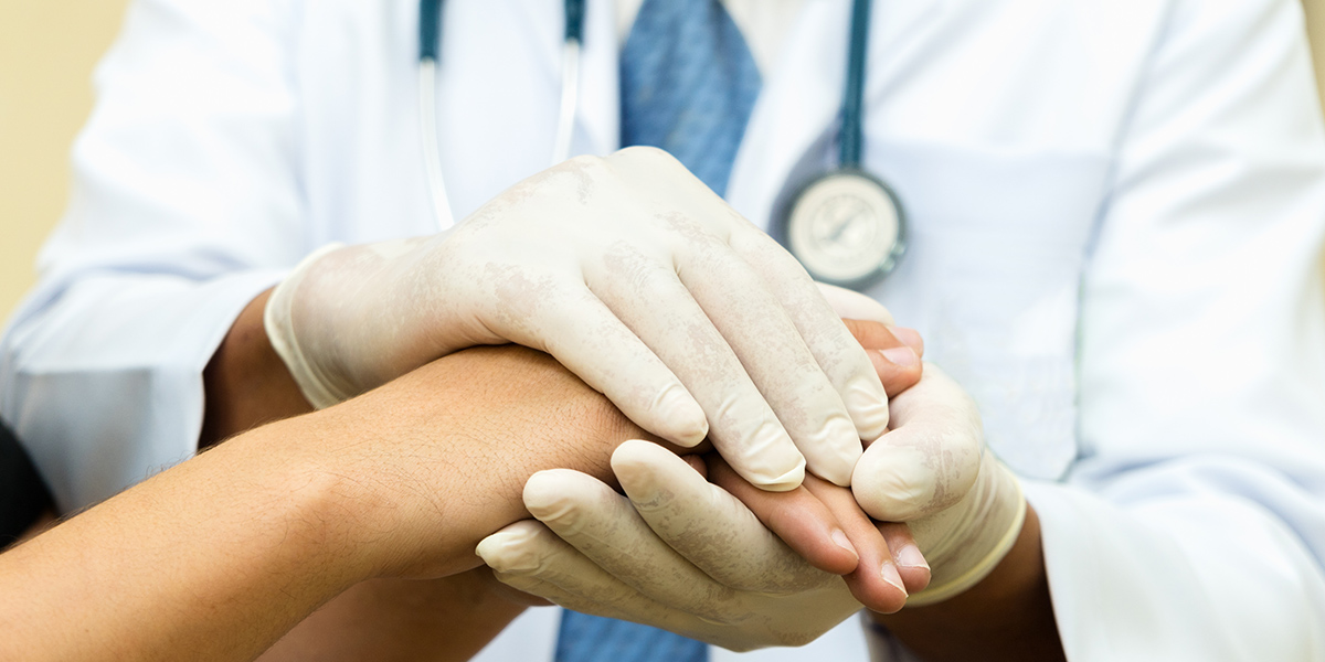 Stock photo of physician holding a patients hand