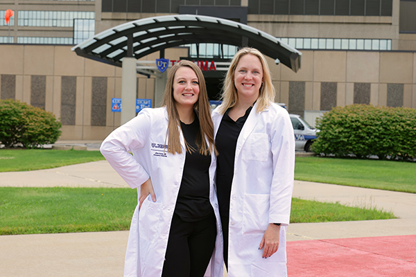 chief residents Sarah Powell, D.O. and Jillian Weiss, M.D. standing outside the UTMC hospital