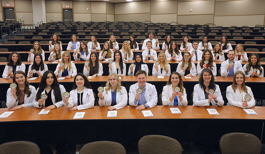 Students hold their new patches for their white coats.