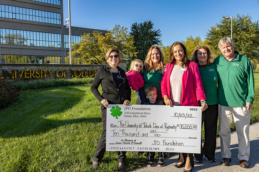 Dr. Cheryl McCullumsmith, chair in the Department of Psychiatry, and Dr. Jamie Dowling, assistant professor in the Department of Psychiatry, hold the check from the James Patrick O'Connell (JPO) Foundation with members of the O’Connell family. 