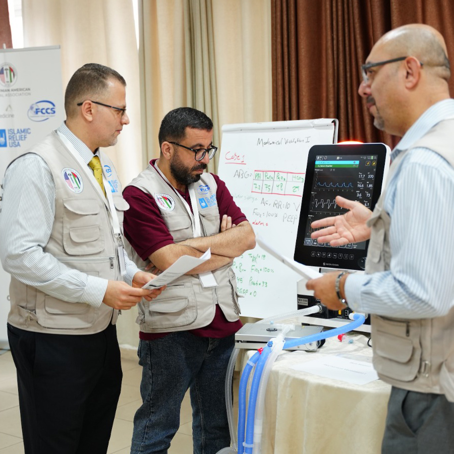 Dr. Fadi Safi and colleagues review a case scenario and ventilator settings with a participant during the FCCS critical care workshop in the West Bank.