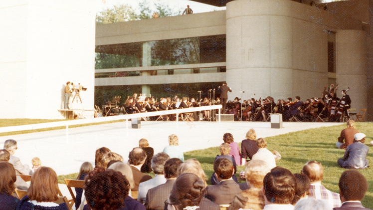 A photo from the grand opening of the Mulford Library 50 years ago outside of the library with a crowd of people for the press conference opening ceremony.