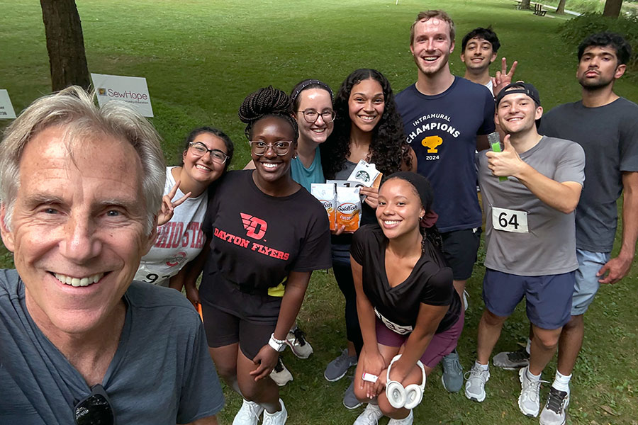 Students pose for a selfie with event organizer and retired UToledo faculty member Randy Ruch at the event. 