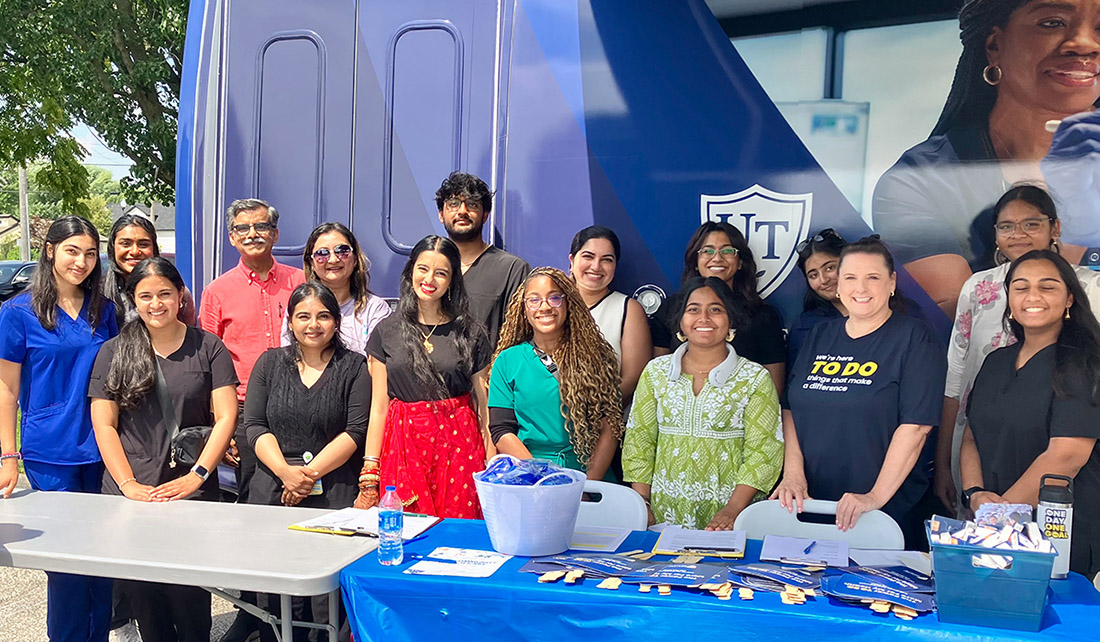 Members of the UToledo community post for a group photo in front of the UToledo Health mobile unit during the Community Health-fare during the Festival of India.  
