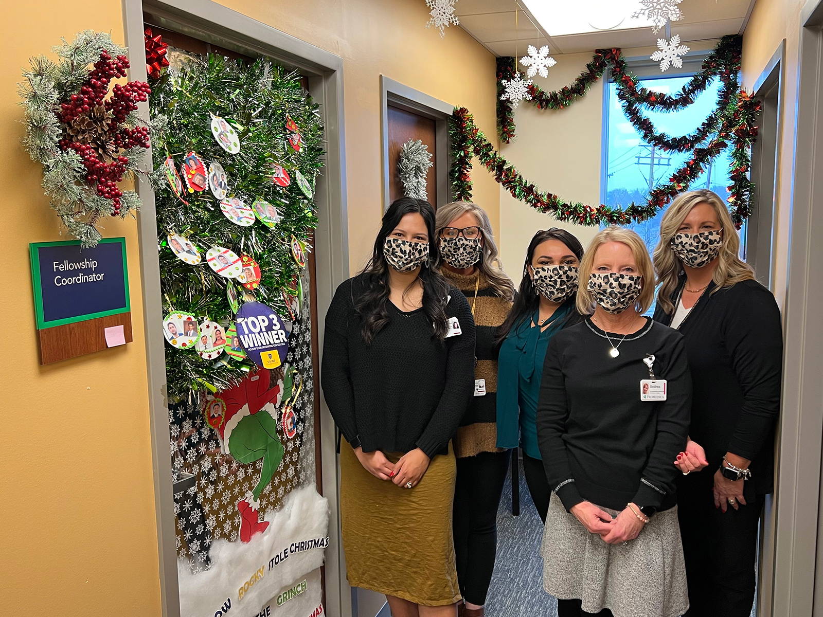 Staff members stand in front of their decorated door