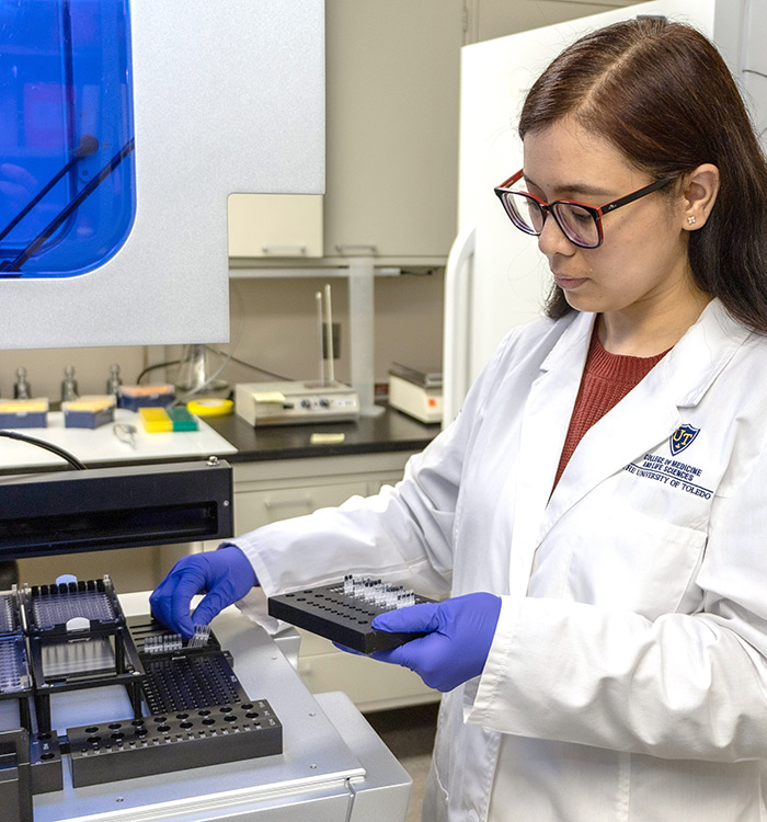 Photo of student performing research in lab