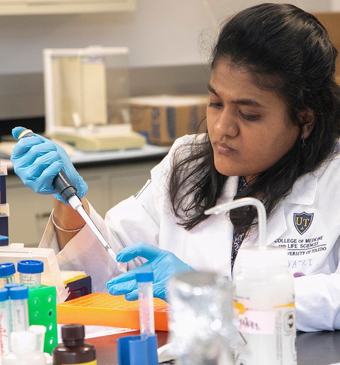 Photo of student performing research in lab