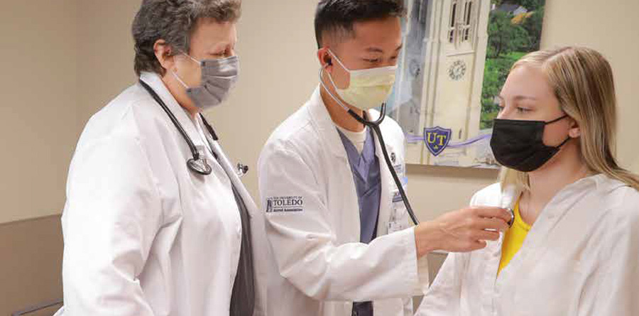 Student examines a patient during clinical rotations with a faculty member.