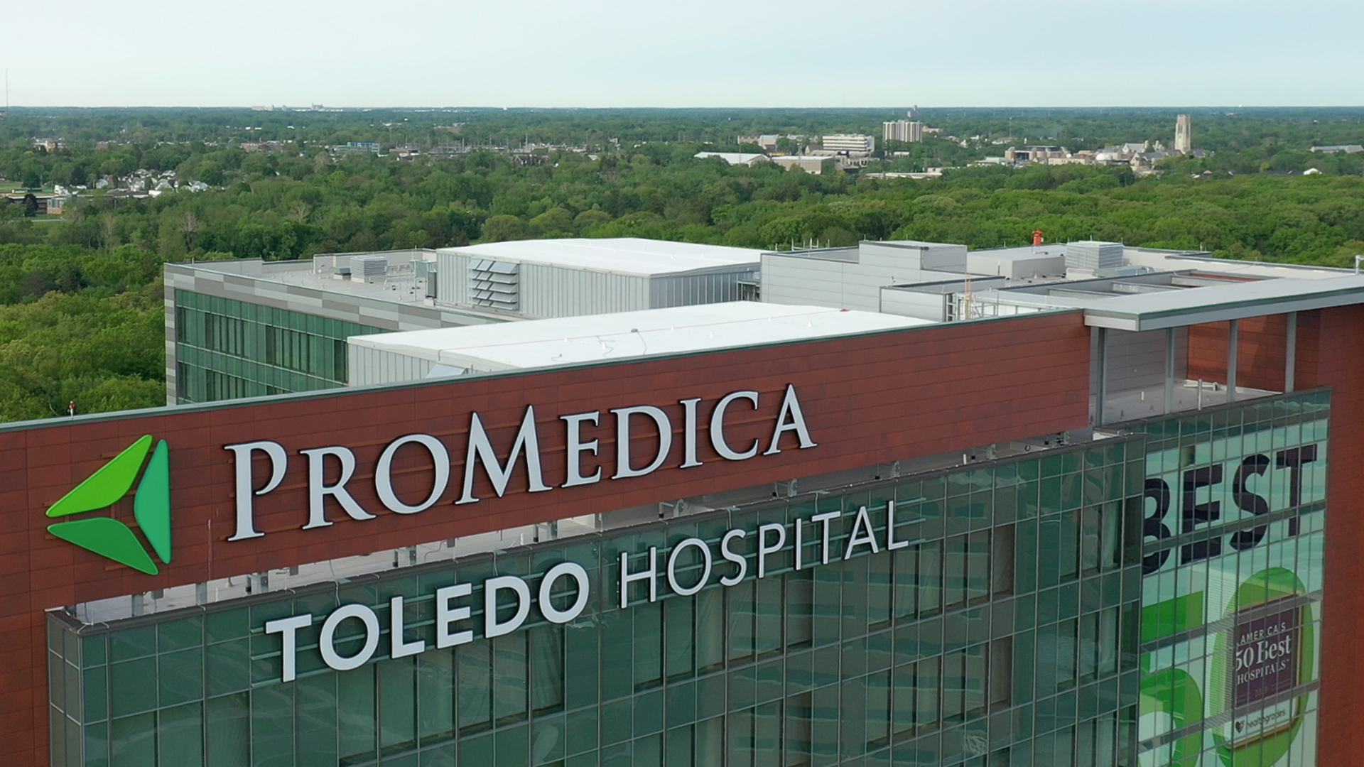 Photo of ProMedica Toledo Hospital with UToledo in the background.