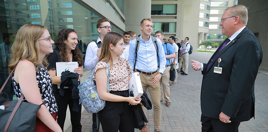 Photo of Dr. Worth interacting with medical students outside of Mulford Library during orientation