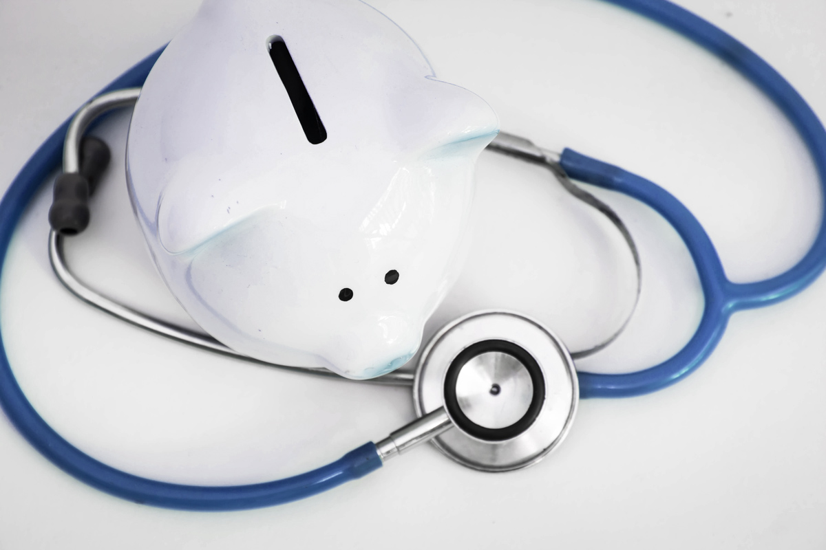 A stock image of a piggy bank surrounded by a stethoscope. 
