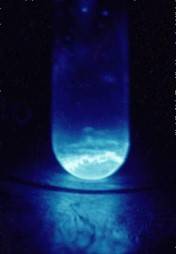 Blue glowing Einsteinium in beaker