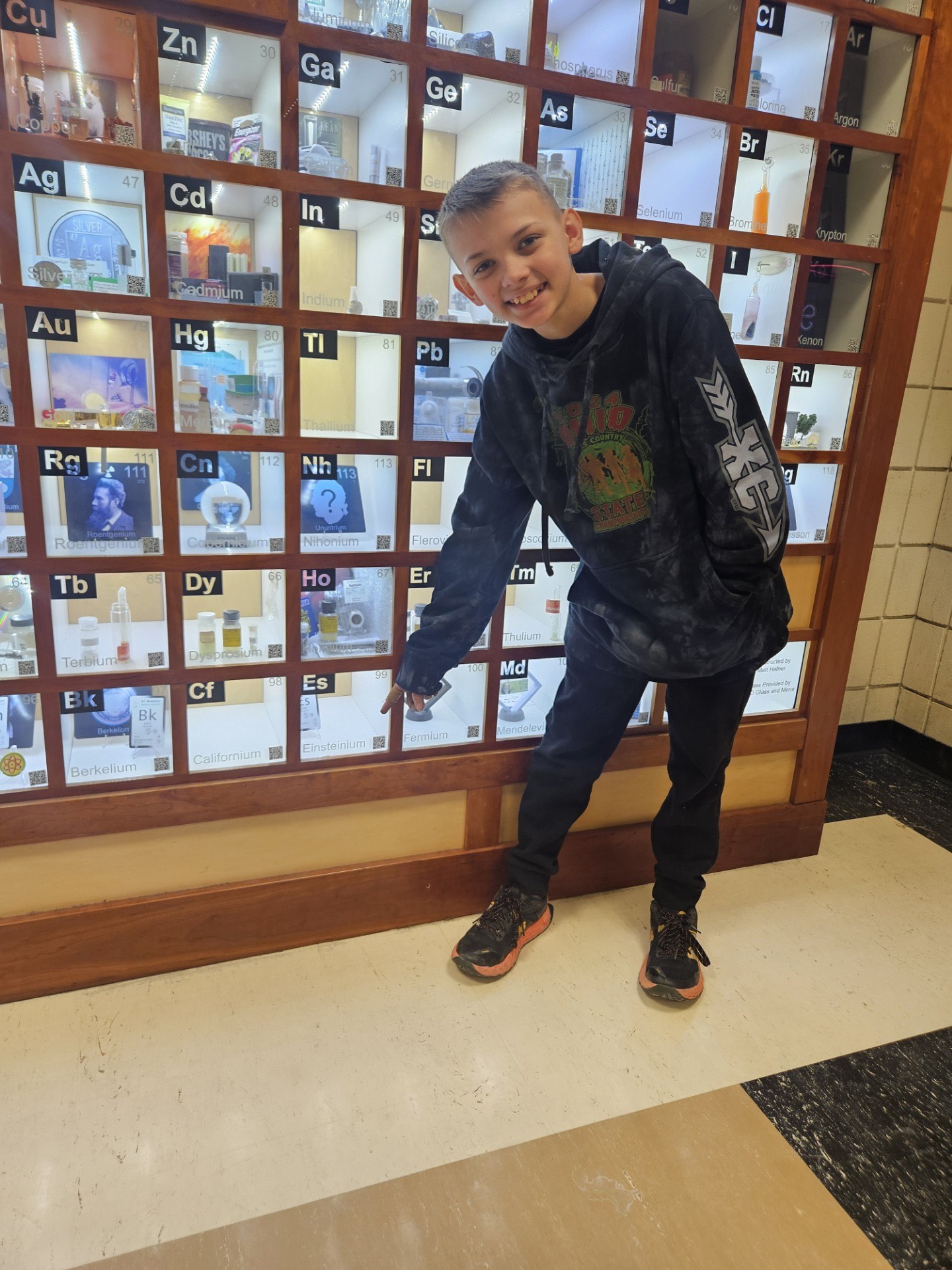 Student posing with the Einsteinium display box they filled. 